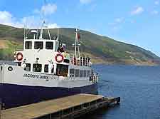 Photo of the expansive Loch Ness and a cruise boat awaiting passengers
